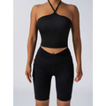 Black athletic crop top with crisscross halter neck and high waist workout bike shorts with side pockets