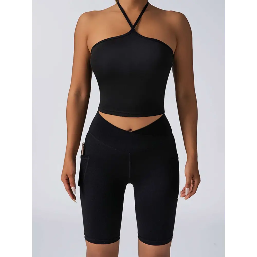 Black athletic crop top with crisscross halter neck and high waist workout bike shorts with side pockets