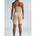 Beige ribbed high waist workout bike shorts with seamless form fitting design and small black logo on the side