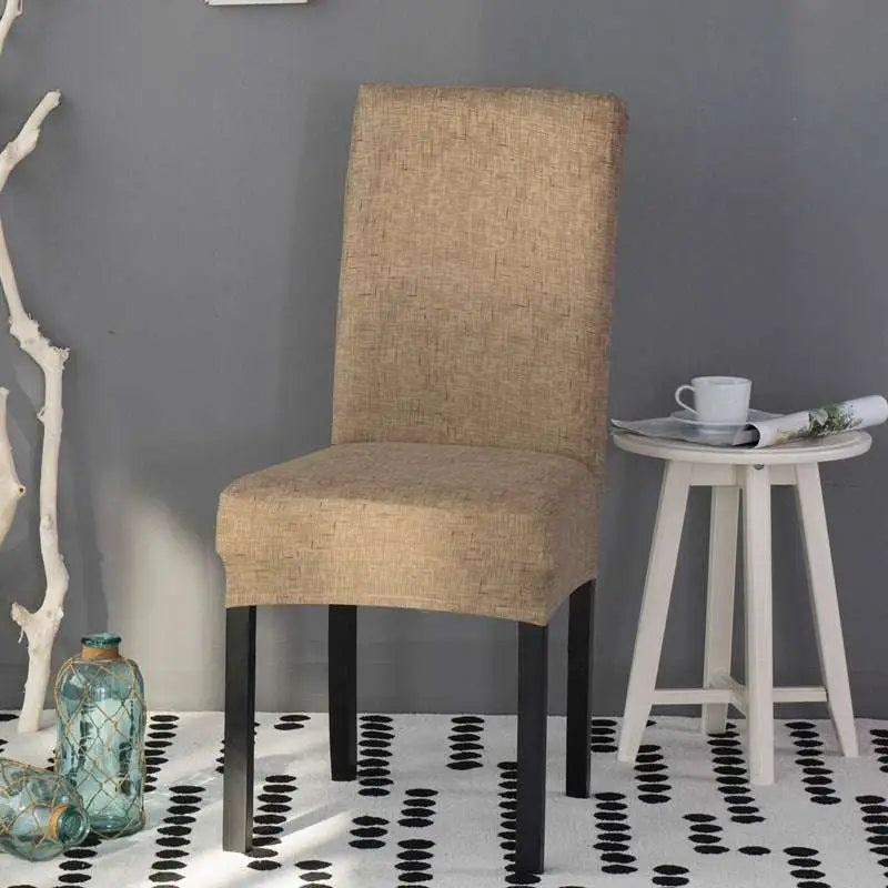 Beige textured universal chair cover on a chair with black metal legs showing a soft fabric texture