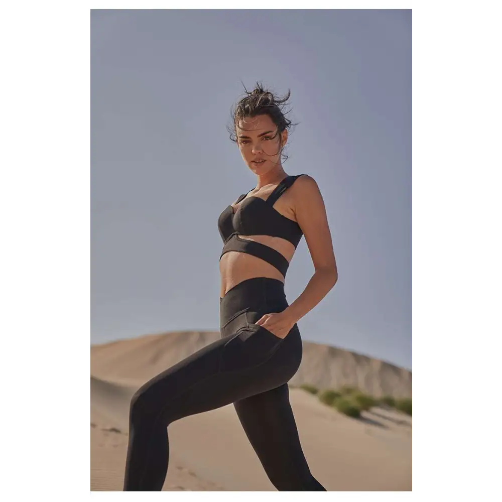 Black athletic two-piece set with sleek cut-out design complementing beige yoga pants and sport coat fitness set