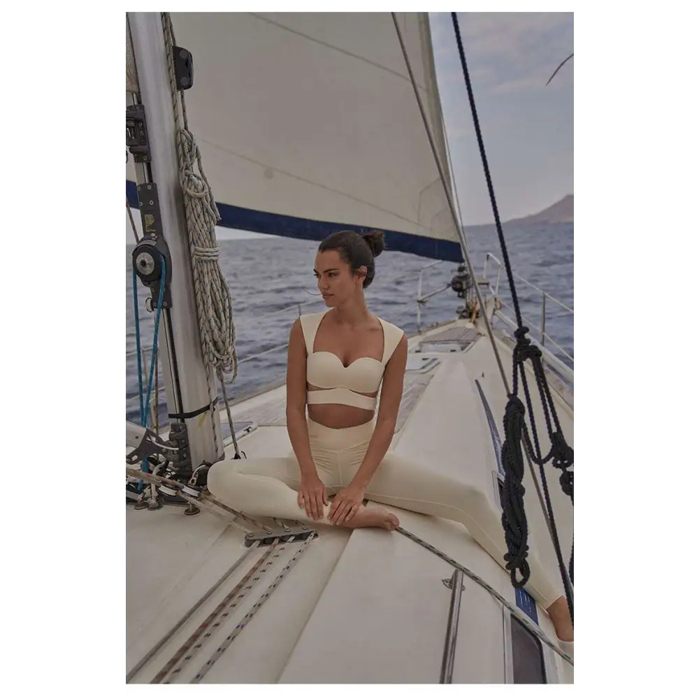 Cream-colored form-fitting two-piece sport coat fitness set with beige yoga pants and a cropped top for activewear