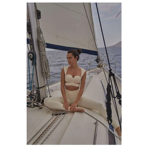 Cream-colored form-fitting two-piece sport coat fitness set with beige yoga pants and a cropped top for activewear