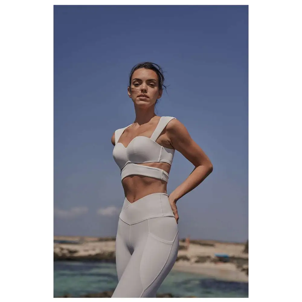 White athletic two-piece set with sleek form-fitting design and subtle seam detailing for sport coat fitness use