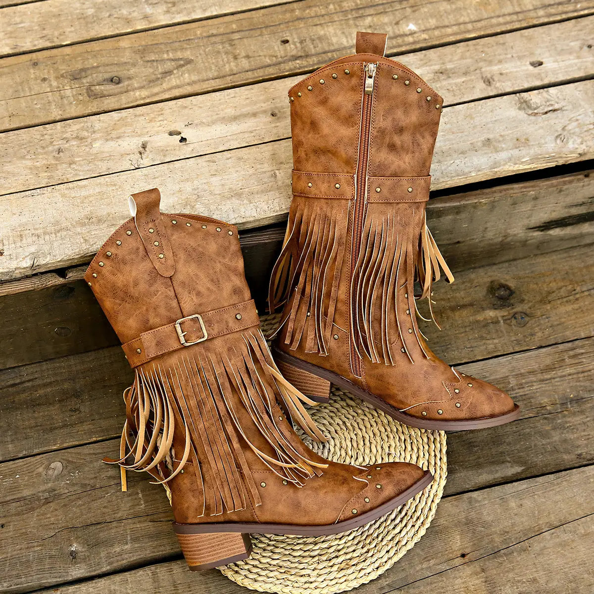 Brown suede cowboy boots with fringe and metal studs featuring a retro winter fashion square heel design.