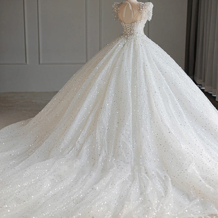 a sparkling beaded white wedding dress featuring intricate beading and a voluminous tulle skirt ideal for white floral wedding or a floral wedding dress occasion