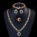 Rose gold jewelry four-piece suit with emerald green stones and clear zircon crystals on black mannequin bust