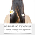 Biotin hair care spray in amber glass bottle with black spray nozzle nourishing long straight hair with ginger droplets