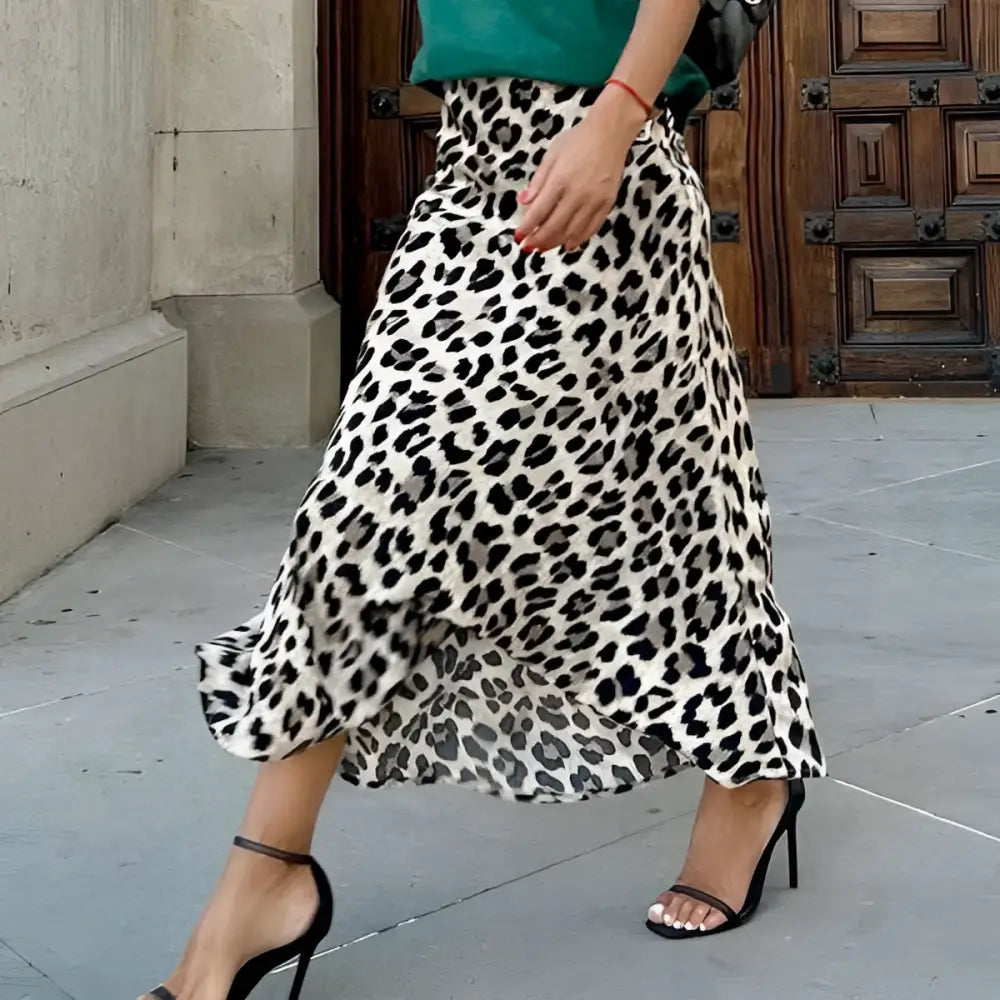 A flowing black and white leopard print elastic a line skirt with lightweight fabric and a flared hem midi length