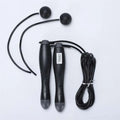 Black cordless electronic skipping rope with textured grips and spherical handles for skipping rope workouts