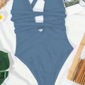 A sleek solid blue one-piece fashion pure color swimsuit with a flattering deep v neck crisscross cutout design