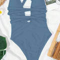 A sleek solid blue one-piece fashion pure color swimsuit with deep v neck and crossed strap cutout design