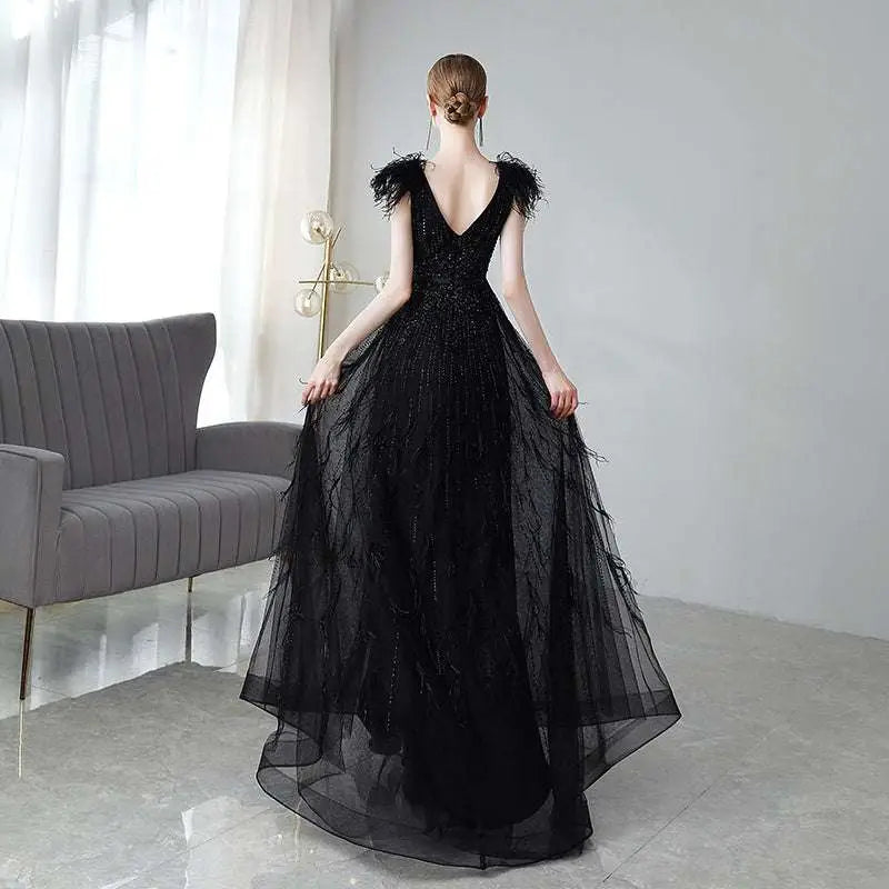 Elegant black double shoulder evening dress featuring feathered shoulder accents and a sparkling sequined bodice
