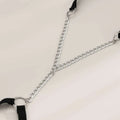 Black elastic geometric body chain thigh garter with silver-toned metal chain and black fabric straps in y-shaped design