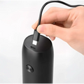 Black cylindrical electric kitchen household grinder with matte finish and circular power button in household grinder set