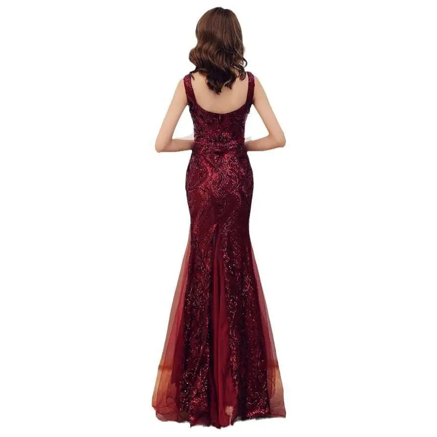 A shimmering burgundy fishtail long summer gown with intricate sequined detailing and a sheer overlay for evening wear