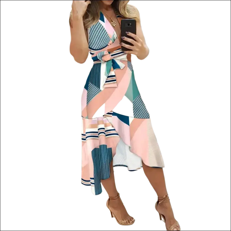 A slim fit wrap dress with a bold geometric pattern in pink teal white and navy blue featuring striped accents
