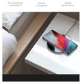 A sleek black glossy 15w smooth wireless charger with a circular design and reflective surface with silver trim