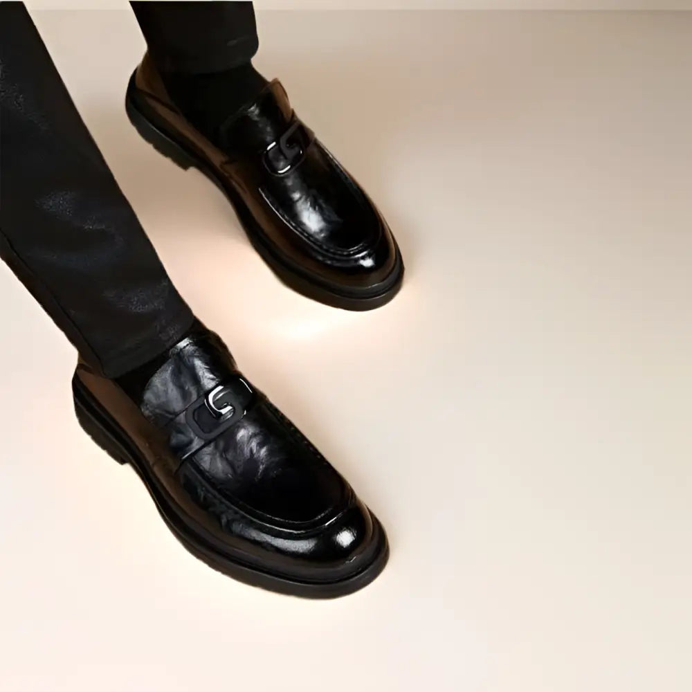 Black glossy business casual leather loafers with a glossy finish and metallic buckle accent for casual leather loafers use