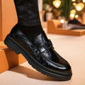 Black glossy business casual leather loafer with prominent buckle detail on the vamp for casual leather loafers use