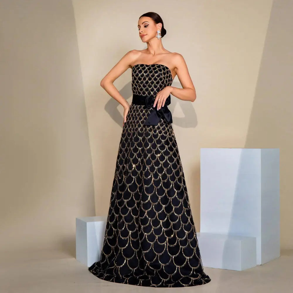 Black strapless large swing sequined evening dress with gold shimmering scale pattern and matching satin waist bow