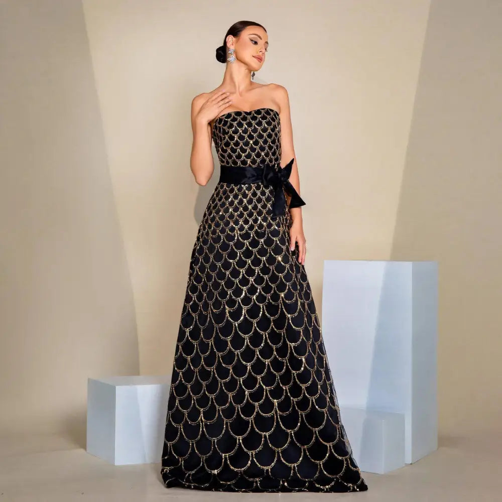 Black strapless large swing sequined evening dress with intricate gold-scale embroidery and matching satin sash at waist