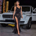 A shimmering black sequined evening dress with a plunging v-neckline and a black high slit for formal occasions