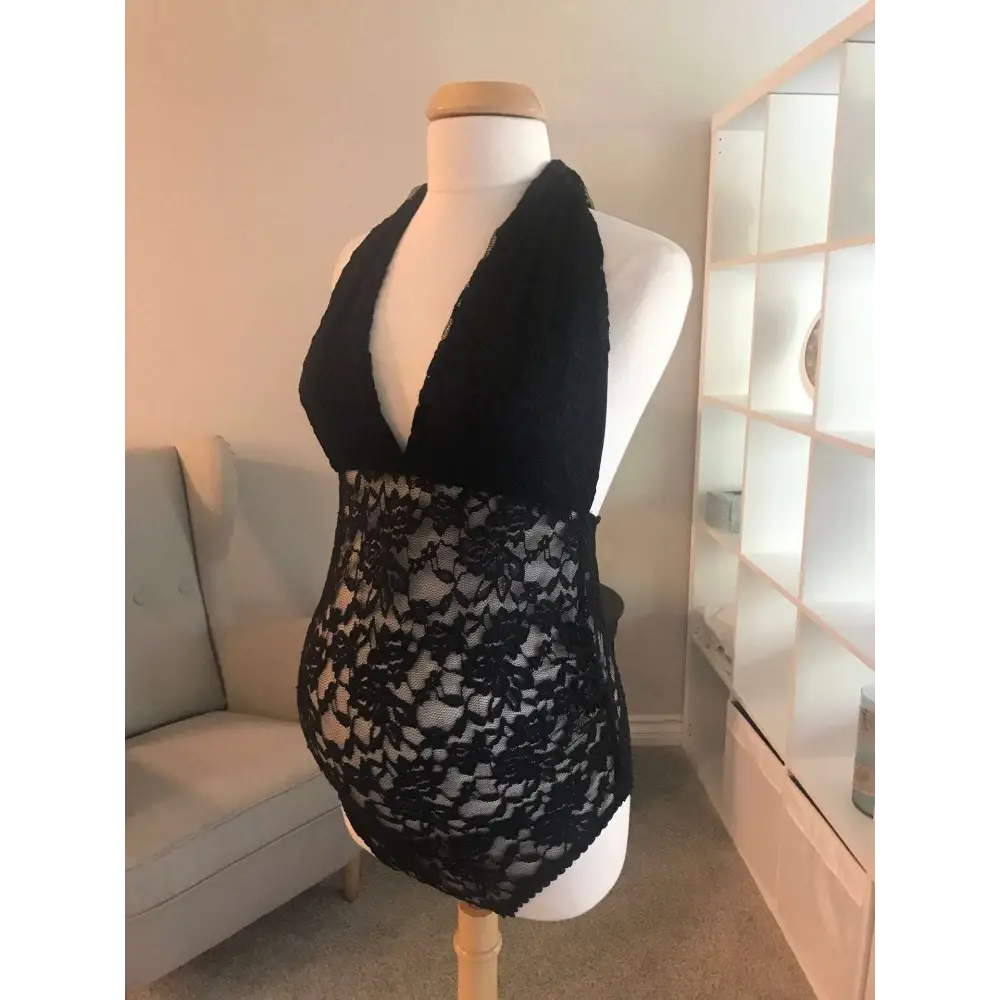 Black lace maternity halter neck shaping bodysuit with floral pattern displayed on a mannequin