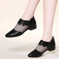 Black lace mesh women’s sandals with floral lace detailing ankle straps and glossy leather toe flats