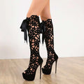 Black lace-up peep toe high heels featuring floral cutout patterns and satin ribbon ties on platform heels