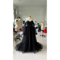 Black long sleeve transparent lace wedding dress featuring a black strapless ball gown with sheer puff sleeves and layered tulle skirt