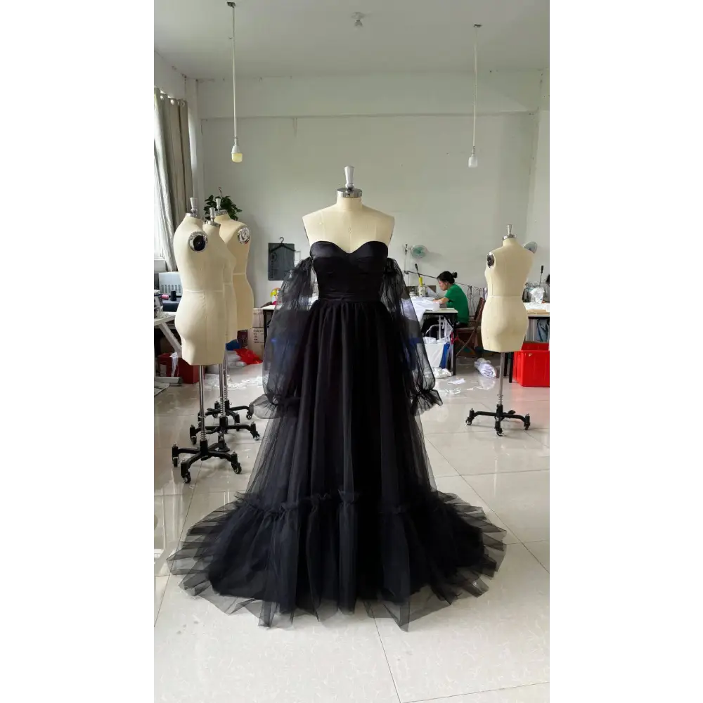 Black long sleeve transparent lace wedding dress featuring a black strapless ball gown with sheer puff sleeves and layered tulle skirt