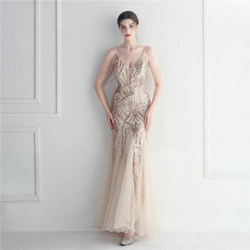 A shimmering champagne evening gown with intricate gold sequin patterns and delicate sheer fabric for bridal wedding dinner