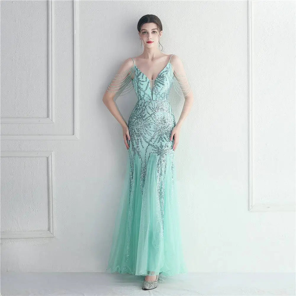 A shimmering mint green mesh beaded bridal wedding dinner gown with intricate silver beading and sheer fabric