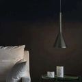 Matte black minimalist funnel pendant light with sleek conical shape hanging from a thin cord for modern interiors