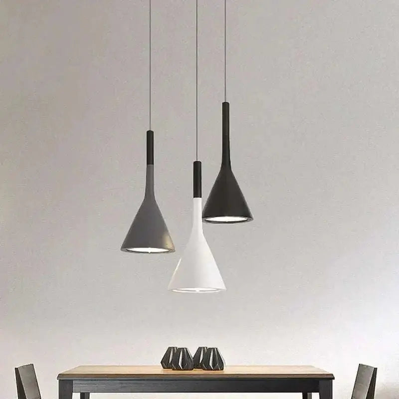 Three modern funnel pendant lights with sleek black minimalist funnel shades suspended above a wooden table