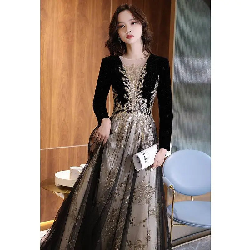 Elegant black moderator long sleeve annual party dress featuring velvet fabric with gold beaded embroidery and sheer layered skirt