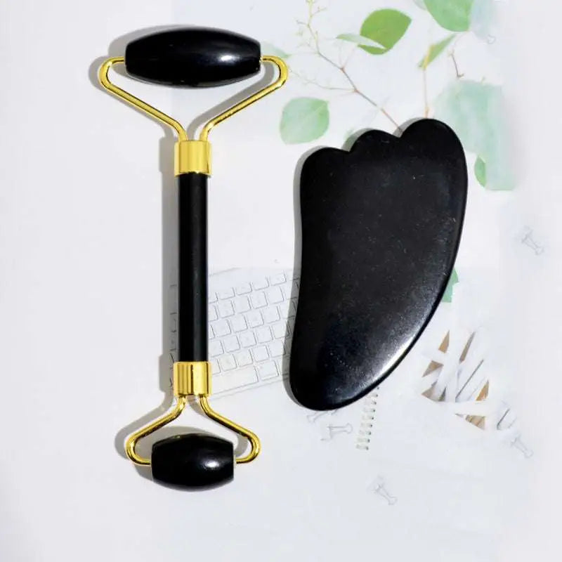 Black obsidian beauty face care massage jade roller with gold-toned metal handles and accents for skincare use