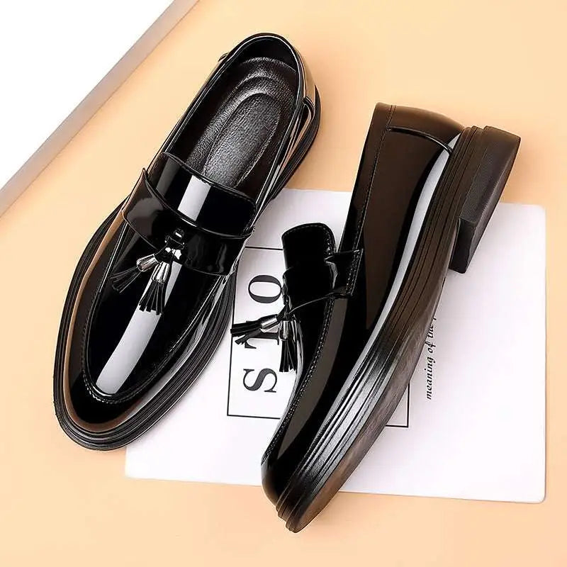 Black patent leather tassel loafers with glossy finish and chunky sole ideal for business formal wear occasions
