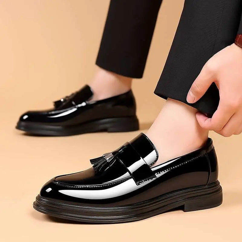 Black patent leather tassel loafers with glossy finish and thick sole for business formal wear