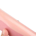 Pink silicone pouch with zipper closure and textured surface accompanying a black plastic pet grooming comb
