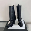 Black leather knight boots featuring pointed toe chunky heel and decorative buckle straps knee-high design