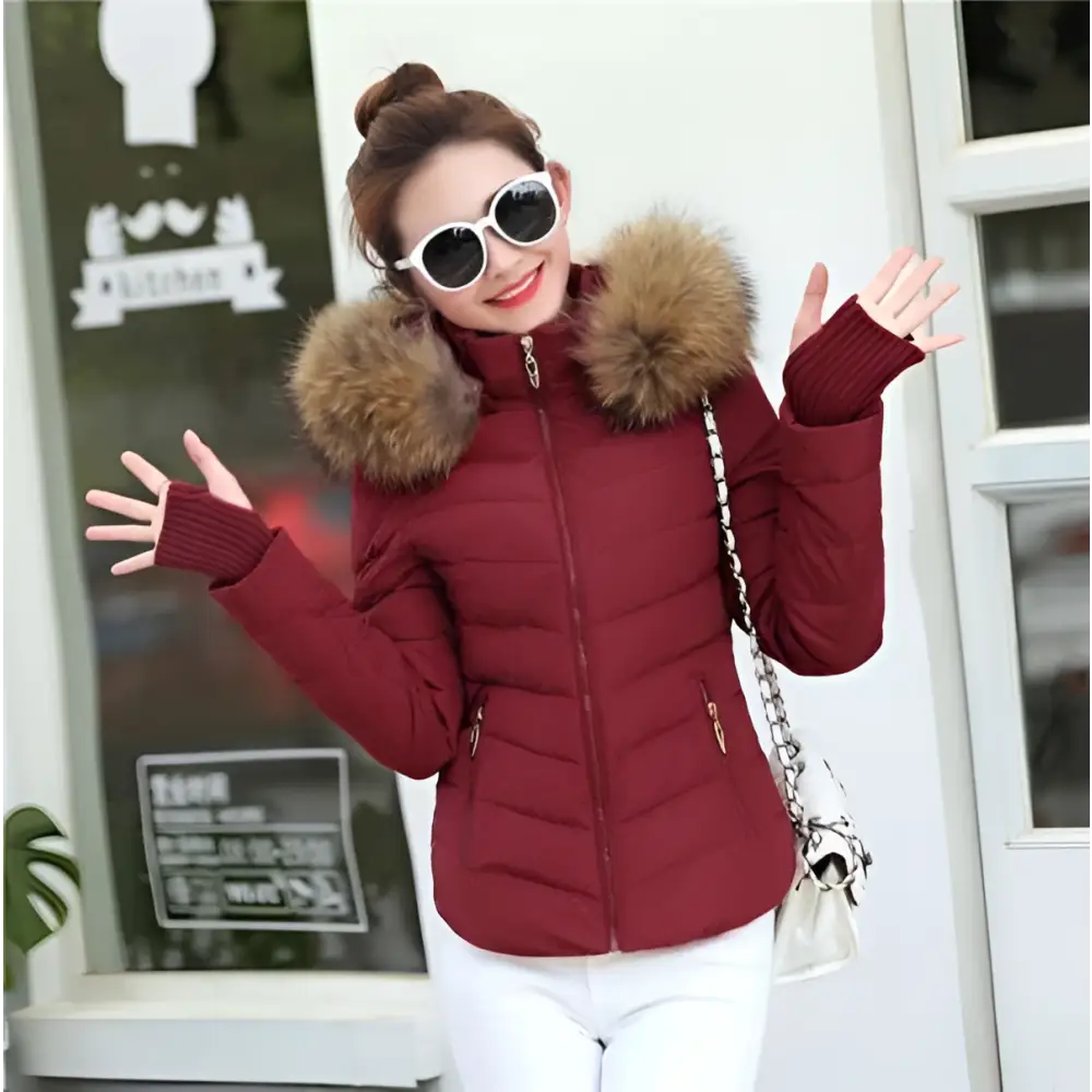 A maroon quilted parka jacket winter womens with plush brown fur-lined hood and ribbed knit cuffs