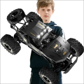 Black remote control rock crawler with rugged tires gold-accented branding and rechargeable batteries