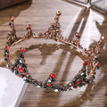 An ornate rose gold crown bridal headdress with red and black gemstones in a black retro circle design