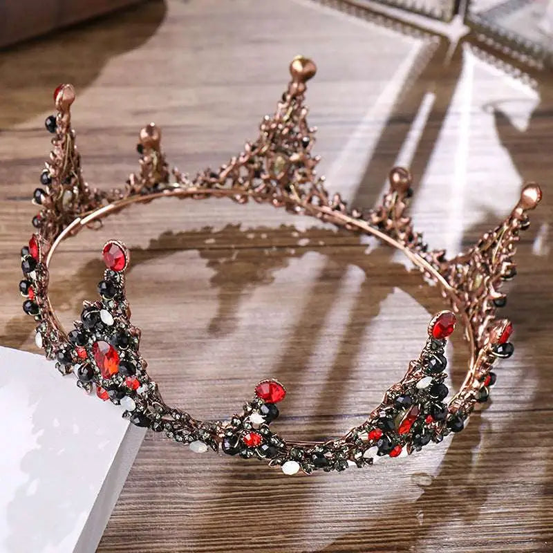 An ornate rose gold crown bridal headdress with red and black gemstones in a black retro circle design