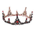 An ornate rose gold crown bridal headdress with black retro circle design adorned with black and red gemstones