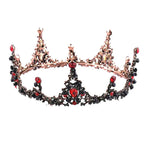 An ornate rose gold crown bridal headdress with black retro circle design adorned with black and red gemstones