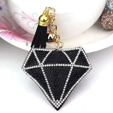 Black diamond-shaped bag pendant with sparkling rhinestones, gold-toned chain, bell, and creative tassel accessory