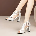 White strappy block heel sandals with textured upper paired with black rhinestone rose mesh fish mouth heels